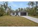 Inviting single-story home featuring a modern design, well-manicured lawn, and long driveway leading to a spacious garage at 2160 7Th Ave, Deland, FL 32724