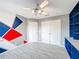 Bright bedroom featuring a ceiling fan, unique geometric wall art, and closet for storage at 2805 Polson Dr, Kissimmee, FL 34758