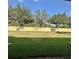Large backyard featuring a yellow wall, green trees, a well-maintained lawn, and a privacy barrier at 2946 Ashland S Ln, Kissimmee, FL 34741