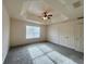 Cozy bedroom featuring tray ceiling, fan, and carpet at 2946 Ashland S Ln, Kissimmee, FL 34741