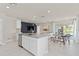 Modern open-concept kitchen with stainless steel appliances, an island, and an adjacent dining area at 3626 Cambridge Brook Dr, Davenport, FL 33837