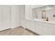 Modern bathroom featuring dual sinks, white cabinets, and a large mirror at 425 Singing Sands Cir, Lake Wales, FL 33859