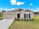 Charming one-story home with a two-car garage, neutral paint, and well-maintained landscaping at 425 Singing Sands Cir, Lake Wales, FL 33859