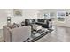 Spacious living room featuring modern gray sofas and a decorative rug on tile flooring at 425 Singing Sands Cir, Lake Wales, FL 33859