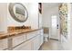 Bathroom with granite counter, white cabinets, round mirror, and shower at 432 Wilderness Dr, Longwood, FL 32779