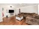 A cozy living room with hardwood floors, a comfortable couch, and a large television at 432 Wilderness Dr, Longwood, FL 32779