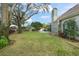 Spacious backyard featuring a lush lawn, mature trees, and a pool with waterfall at 5138 Fairway Oaks Dr, Windermere, FL 34786