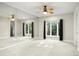 Spacious bedroom featuring an accent wall with a large mirror and a ceiling fan at 5138 Fairway Oaks Dr, Windermere, FL 34786