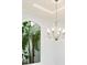Bright dining room featuring an elegant chandelier and an arched window with lush tropical plants at 5138 Fairway Oaks Dr, Windermere, FL 34786