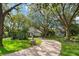 View of home featuring mature trees, beautiful landscaping, and a winding brick driveway enhancing curb appeal at 5138 Fairway Oaks Dr, Windermere, FL 34786
