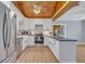 Modern kitchen featuring white cabinets, stainless steel appliances, wood ceiling, and black countertops at 525 S Crystal Lake Dr, Orlando, FL 32803