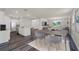 Open concept living space with a kitchen island, dining table, and living area with natural light at 5614 Paddock Fence Ln, Apopka, FL 32712