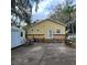 Inviting backyard with a deck, grill, and exterior view of the yellow home featuring unique round windows at 615 S Laurel Ave, Sanford, FL 32771