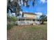 Charming two-story yellow home with a welcoming porch and mature landscaping at 615 S Laurel Ave, Sanford, FL 32771