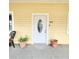 Inviting front door with decorative glass, potted plants, and house number visible at 615 S Laurel Ave, Sanford, FL 32771