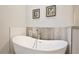 Close-up of a modern soaking tub with stylish fixtures and tile accents in a bright bathroom at 702 Pelican Ct, Kissimmee, FL 34759