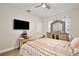 Inviting bedroom with wood-look flooring, a ceiling fan, and a large dresser and mirror combo at 702 Pelican Ct, Kissimmee, FL 34759