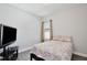 Cozy bedroom with a queen bed, window, and TV, perfect for relaxation and comfort at 702 Pelican Ct, Kissimmee, FL 34759