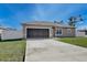 Charming single-story home featuring a well-manicured lawn and attached one-car garage at 702 Pelican Ct, Kissimmee, FL 34759