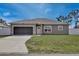 Charming single-story home featuring a well-manicured lawn and attached one-car garage at 702 Pelican Ct, Kissimmee, FL 34759