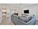 Open-concept living area with hardwood floors, a plush sofa, and modern entertainment center at 702 Pelican Ct, Kissimmee, FL 34759