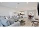 Cozy living room with hardwood floors, a plush sofa, and an open concept to the kitchen at 702 Pelican Ct, Kissimmee, FL 34759