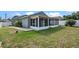 This home features a spacious backyard with green grass and a screened-in patio for outdoor enjoyment at 8519 Rainbow Ave, Orlando, FL 32825