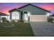 Charming one-story home featuring a two-car garage and well-maintained front lawn at dusk at 8519 Rainbow Ave, Orlando, FL 32825