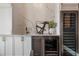 Stylish bar area featuring stainless steel appliances, white cabinets, and marble backsplash in a modern home at 9454 Becker Ct, Orlando, FL 32827