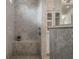 Luxurious walk-in shower in primary bath with marble walls and a built-in bench at 9454 Becker Ct, Orlando, FL 32827