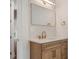 Bathroom featuring a granite counter top, wood cabinets, and modern mirror with decorative towel hangers at 9454 Becker Ct, Orlando, FL 32827