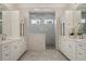 Modern bathroom featuring a spacious glass enclosed shower, marble floors, and double vanity at 9454 Becker Ct, Orlando, FL 32827