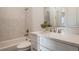 Well-lit bathroom featuring a bathtub, brushed nickel fixtures, and a vanity with a stone countertop at 9454 Becker Ct, Orlando, FL 32827