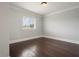 Inviting bedroom with hardwood flooring, a large window with bright natural light, and neutral walls at 9454 Becker Ct, Orlando, FL 32827