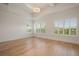 Bright bedroom with three large windows, modern light fixture, tray ceilings, and beautiful hardwood floors at 9454 Becker Ct, Orlando, FL 32827