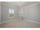 Bedroom featuring neutral walls, white trim, carpet, chandelier, and plantation shutters on the windows at 9454 Becker Ct, Orlando, FL 32827