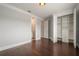 Bedroom featuring wood floors, neutral walls, white trim, and adjoining doors to a bathroom and walk-in closet at 9454 Becker Ct, Orlando, FL 32827