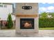 Outdoor stone fireplace with wood mantle and integrated television mount creates a backyard focal point at 9454 Becker Ct, Orlando, FL 32827