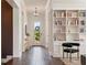 Inviting foyer with dark hardwood floors, built-in bookcase, console table, and view to backyard at 9454 Becker Ct, Orlando, FL 32827