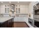 Bright kitchen featuring white cabinetry, stainless steel appliances, and a large island with pendant lighting at 9454 Becker Ct, Orlando, FL 32827