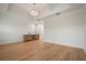 Open living room with hardwood floors, tray ceiling, modern light fixture, and a built-in bar with a marble backsplash at 9454 Becker Ct, Orlando, FL 32827