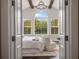 Open bedroom with high ceilings, beams, large windows offering a view, and cozy seating area at 9454 Becker Ct, Orlando, FL 32827
