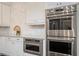 Modern kitchen with stainless steel ovens and white cabinetry at 9454 Becker Ct, Orlando, FL 32827