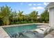 Sparkling pool features in-pool loungers, lush landscaping, and an attached jacuzzi at 9454 Becker Ct, Orlando, FL 32827