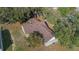 Aerial view of a home surrounded by mature trees, showcasing its roof and yard space at 10320 Bumblebee Ln, Leesburg, FL 34788
