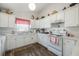 Well-lit kitchen with white cabinets, modern appliances, and wood-look flooring at 10320 Bumblebee Ln, Leesburg, FL 34788