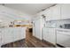 Open kitchen with white appliances, wood-look floors, and ample counter space at 10320 Bumblebee Ln, Leesburg, FL 34788