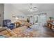 Spacious living room featuring a ceiling fan and a cozy fireplace at 10320 Bumblebee Ln, Leesburg, FL 34788