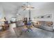 Open living room featuring neutral-toned furnishings, a ceiling fan, and seamless flow to other living spaces at 10320 Bumblebee Ln, Leesburg, FL 34788