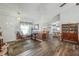 Open-concept living room with wood floors, seamlessly flows to kitchen and dining room at 10320 Bumblebee Ln, Leesburg, FL 34788